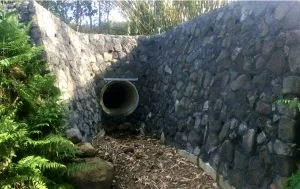 Rock wall with a waterway outlet.